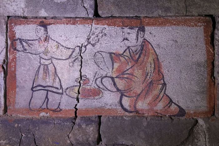 在嘉峪关魏晋墓六号墓的画像砖上，仆人（左）拿着烤肉递给衣着华丽的男主人享用（5月13日摄）。新华社记者 马希平 摄