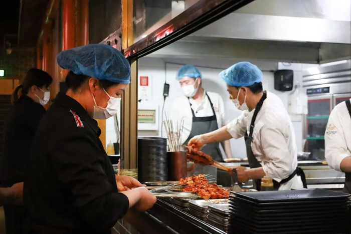 5月12日，在嘉峪关市的一家烤肉店，服务员在窗口取菜。新华社记者 马希平 摄