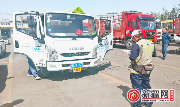 在新龙河二手车交易市场登记服务站，工作人员对车辆进行外检。（全媒体记者彭芳摄）