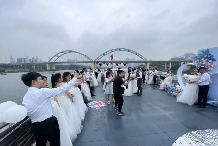 新人们在游船上拍照留下美好一刻。覃祖稳 摄