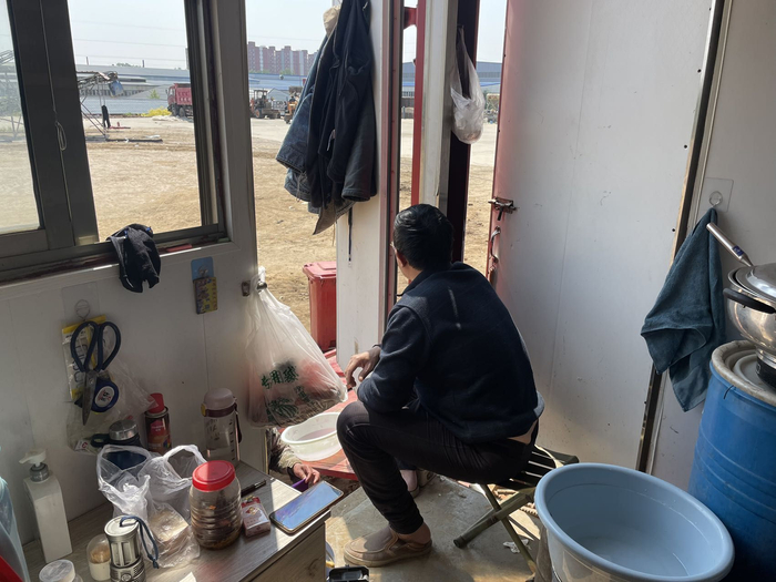  陈华在卡车里监督团员干活。新京报记者 史航 摄