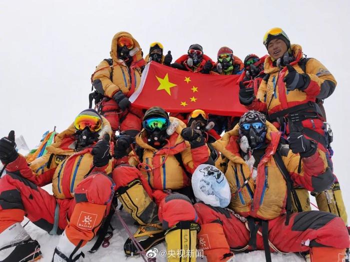 科考登山队员在珠峰峰顶展示五星红旗。图片来源：@央视新闻