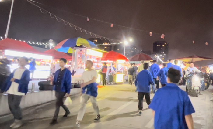比亚迪长沙雨花工厂2号门对面驾校场地里的宵夜摊。摄影/刘丁