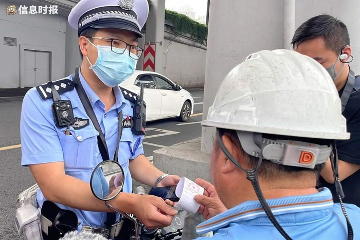交警现场发放“首次违法警告告知书”。信息时报记者 王智汛 摄