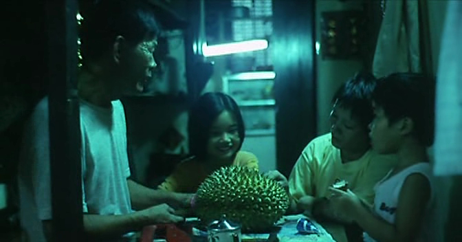 电影《榴莲飘飘》里秦燕一家吃榴莲的场景。（图/电影剧照）