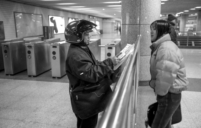 2003年，一名快递员在站厅与自己人交接货物，他们依托地铁的便捷性来做快递生意。澎湃新闻记者 许海峰 摄影