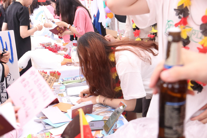 很多人手持“护照”到各个展棚前盖章打卡。图/北京语言大学