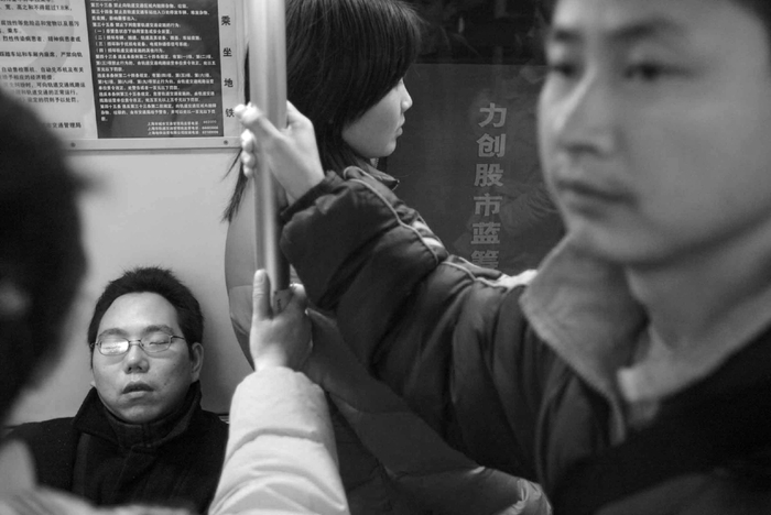 2004年1月19日，一名男子在车厢内闭目养神。随着地铁向城市外围延伸，人们的出勤时间大大增加。澎湃新闻记者 许海峰 摄影