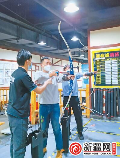 上图：在大巴扎美食街的一家烤肉摊位，员工跳起欢快的舞蹈，吸引游客驻足拍照。