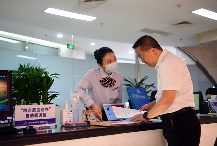北京经开区政务服务中心“跨省通办”窗口，工作人员正在帮助企业办理跨省业务。 和冠欣摄