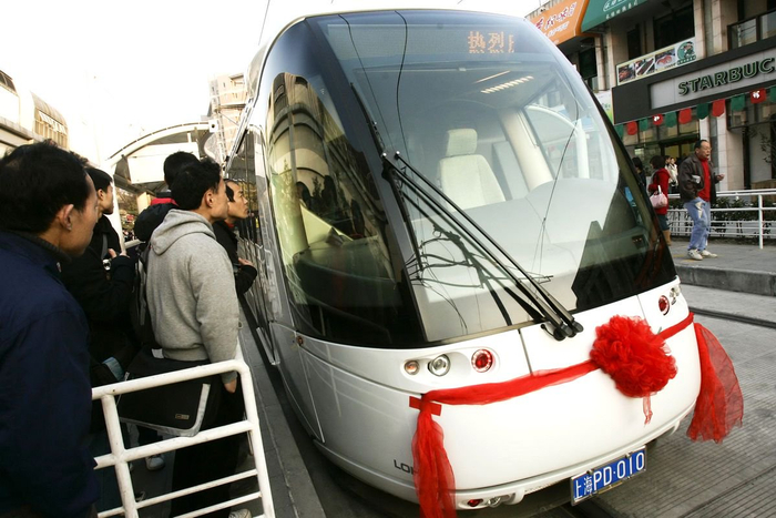 2009年12月31日，市民好奇地看着挂着红花的张江有轨电车。澎湃新闻 资料图