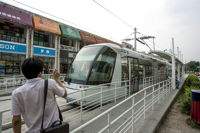 2009年8月18日，在张江地铁站旁，有轨电车正在线上进行调试运行，好奇的市民记录这一刻。澎湃新闻 资料图