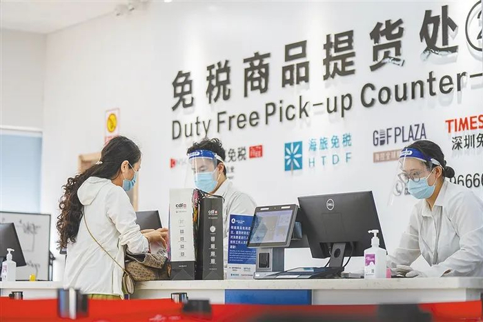 游客在海口新海港码头提货中心提取免税品。（资料图）