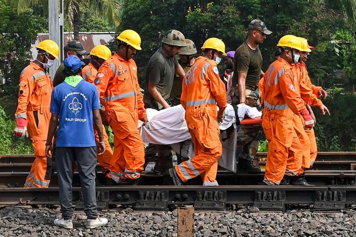 当地时间2023年6月3日，印度东部奥迪沙邦，三列火车相撞事故现场，救援人员抬着受害者的尸体。视觉中国 图