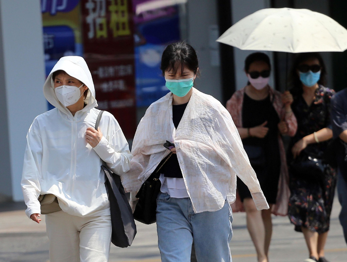 2023年6月2日，南京，高温天气，市民“全副武装”出行。  视觉中国 图