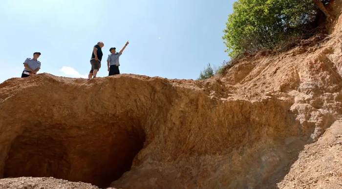 5月19日，办案民警与群众在盗采磷矿现场勘查。