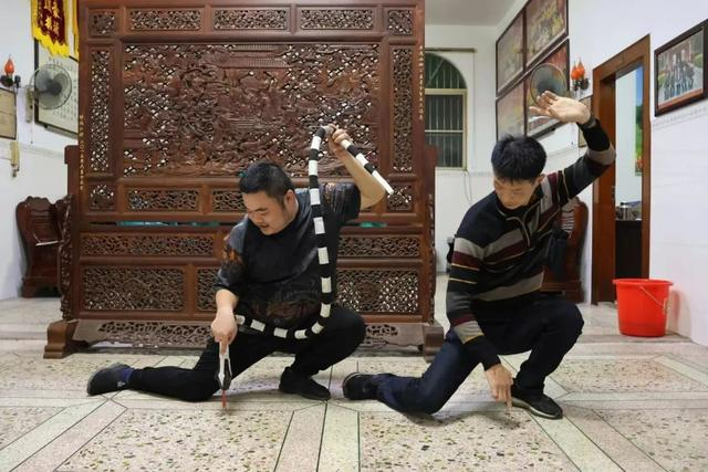 老溪西英歌队，“肥蛇”陈志辉和教练陈宋琪在商量新动作。农民日报·中国农网见习记者 郭诗瑀 摄