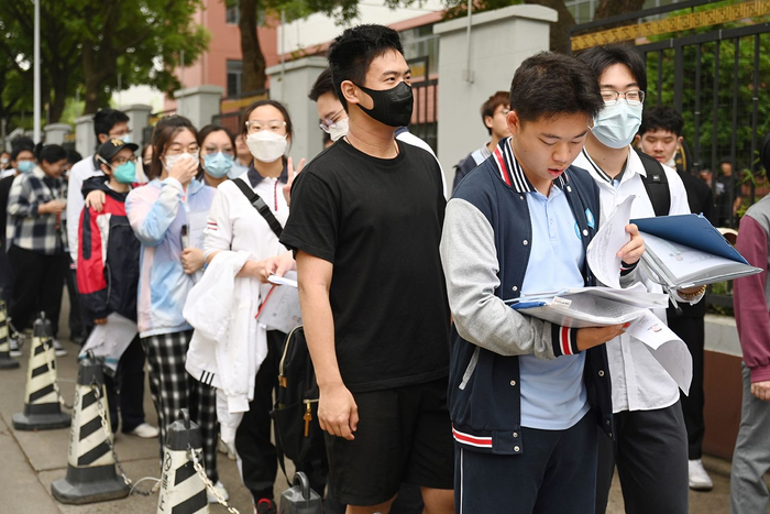 2023年6月7日，上海，华东理工大学附属中学考点，考生在排队进考场时看书复习。澎湃新闻记者 朱伟辉 图