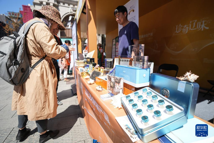 一名游客在展台前驻足，仔细挑选。新华社记者潘昱龙摄