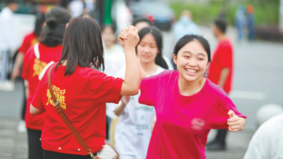 在贵州省赤水市第三中学考点门口，老师为步入考场的考生加油鼓劲。王长育摄（新华社发）