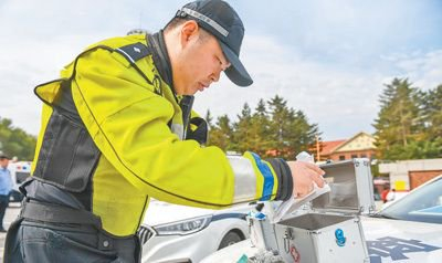 吉林省长春市吉林省实验中学考点外，交警在准备应急药箱。新华社记者 张 楠摄