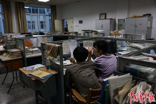 6月5日，浙江诸暨，诸暨职教中心，两名考生在教师办公室里上晚自习。为了更方便向老师请教问题，考试前几天，一些学生自发来到办公室学习。
