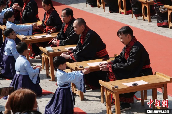 2023年1月，南宁市孔庙新春开笔礼上，身穿汉服的学童在给自己的父母敬茶。喻湘泉 摄