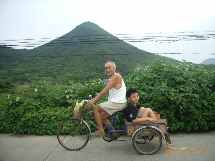 爷孙俩背景里的老网山（2007年夏，黄仕忠摄）