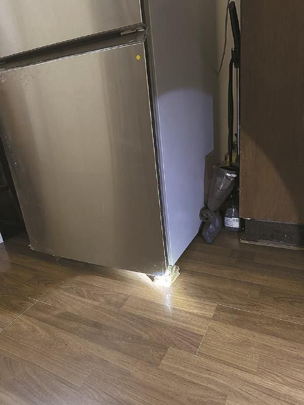             岐山村居民霍白家关不上的阳台门（图左），垫脚才能放稳的冰箱（图右） 屠瑜  摄          