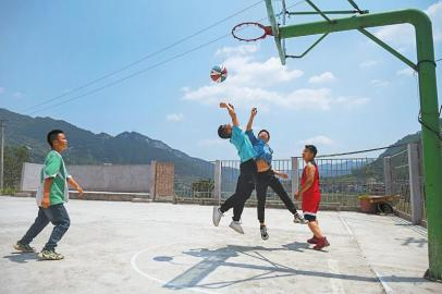 　　5月31日，村民和学生在古蔺县彰德街道小水村的篮球场上切磋球技。