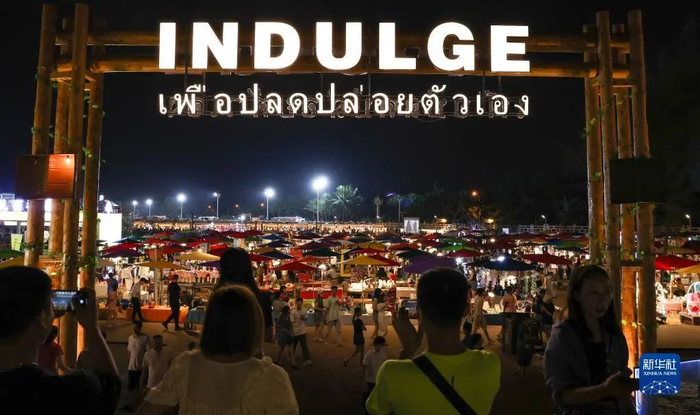 市民游客在海口白沙门文创市集参观拍照（6月12日摄）。新华社记者 杨冠宇 摄