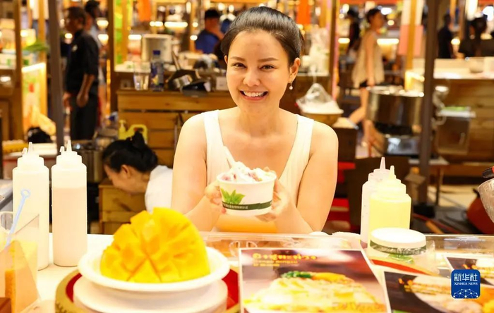 在海口白沙门文创市集，商家展示美食（6月12日摄）。新华社记者 杨冠宇 摄