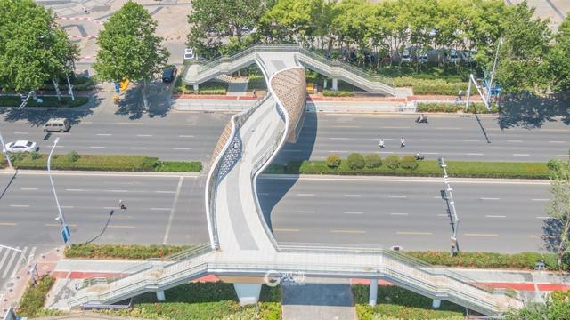 据了解,天桥桥梁上部采用铝单板景观装饰,营造"百川汇海"的视觉效果.