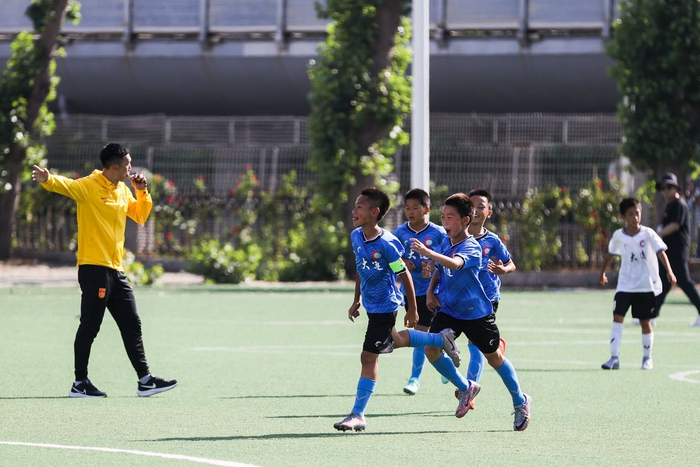 指导小球员踢球 视觉中国供图