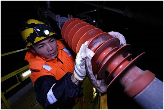 胡朋用抹布擦洗接触网绝缘子。胡鹏 摄