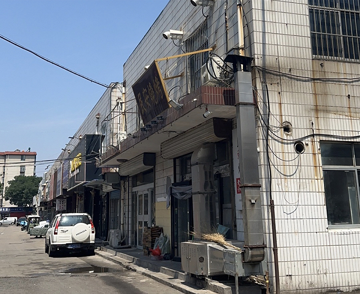 李伟的烧烤小店是一栋二层小楼，店内共有12张烤桌，时代财经王莹岭摄