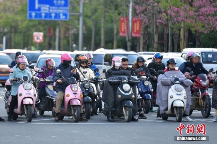 资料图：市民骑电动自行车出行。王以照 摄