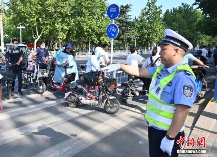 资料图：交警检查违规电动自行车。中新社记者 翟羽佳 摄