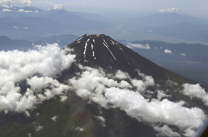 当地时间2023年6月17日，日本，从一架喷气式飞机上拍摄的横跨山梨县和静冈县的日本最高峰富士山。视觉中国 图