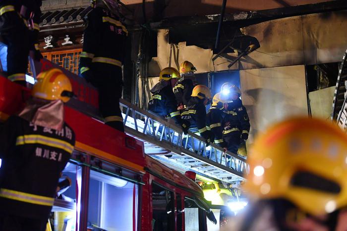 6月21日，消防救援人员在事故现场救援。图片来源：新华社