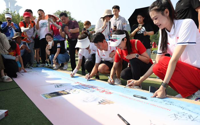 参加活动的运动员代表在横幅上签名。新京报记者 王飞 摄