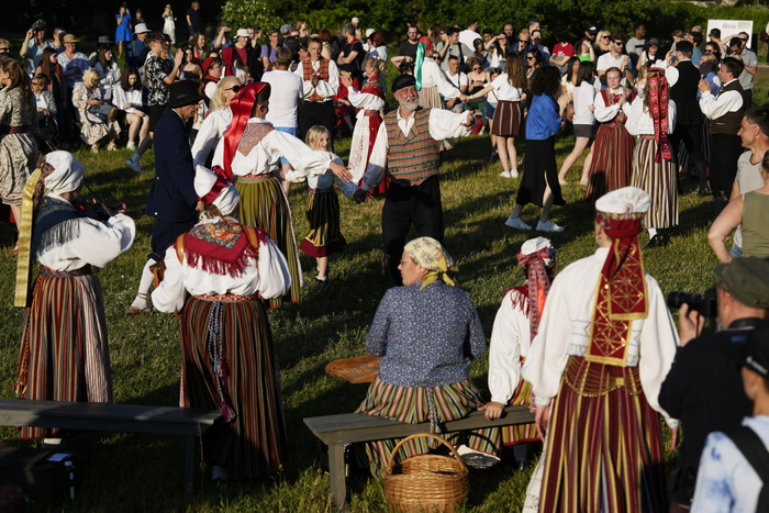 6月23日,在爱沙尼亚塔林,人们身穿传统民族服装翩翩起舞,庆祝仲夏节.