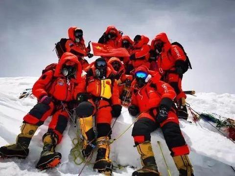 △2020年5月27日，13名珠峰科考队员成功登顶珠穆朗玛峰，与国旗合影。图片来源：科技日报
