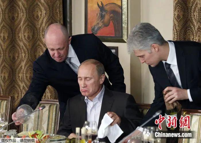 2011年11月11日，俄罗斯莫斯科境界的一家餐厅，普里戈任（左）在为普京（中）上菜。