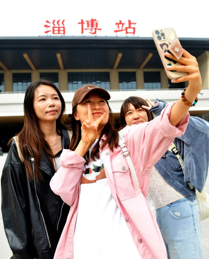 4月14日，山东省淄博市，从北京专程赶来品尝淄博烧烤的游客在淄博火车站广场拍照打卡