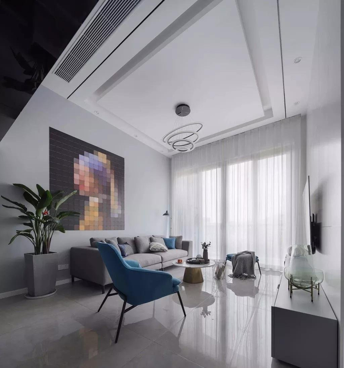 客厅的电视背景墙是直接用了白色的大理石瓷砖,底部加上蓝灰色的电视