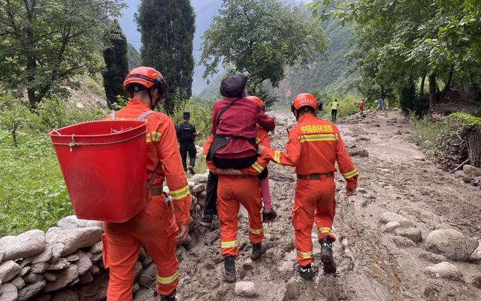 消防救援人员转移被困群众。  图源：四川森林消防总队阿坝支队