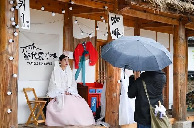 6月22日，端午节假期，身着民族服饰的游客在位于延吉市的中国朝鲜族民俗园内的一家咖啡店里打卡拍照。新华社记者 颜麟蕴 摄
