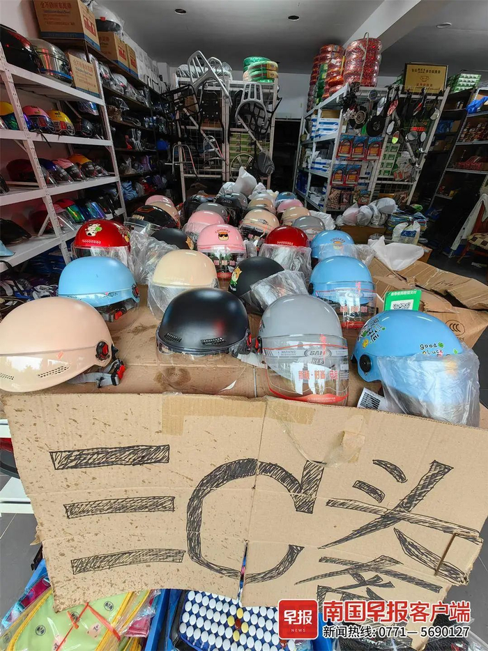 ▲南宁市一家电动自行车用品店内，商家在门口挂着“三C头盔”的招牌。