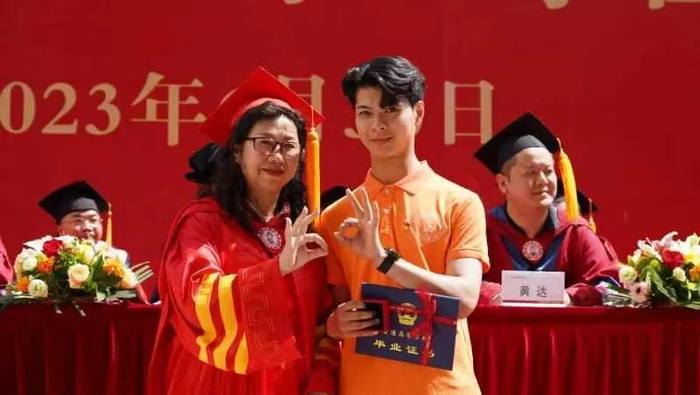 ▲校长蒙丽珍为毕业生代表授予学位并赠送纪念品。